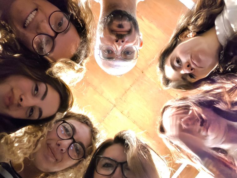 A group of young people standing in a circle, photographed from above, laughing